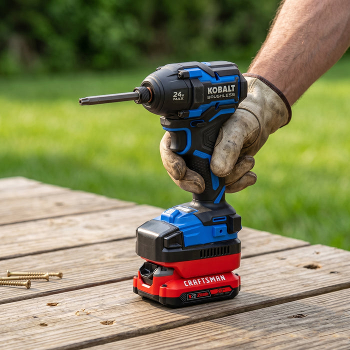 Craftsman 20V to Kobalt 24V battery adapter - installed on an impact driver held in a gloved hand on a wooden deck